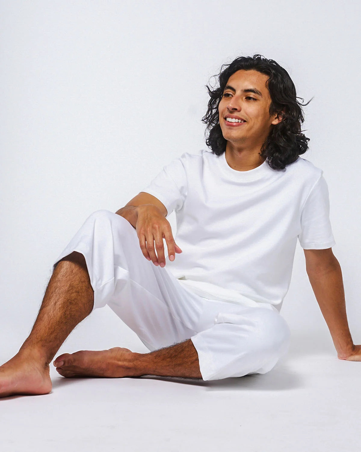 White Everyday Tee model image sitting down on a white background